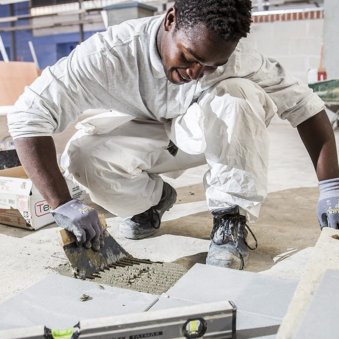 Ouvrier carreleur en entreprise de bâtiment 